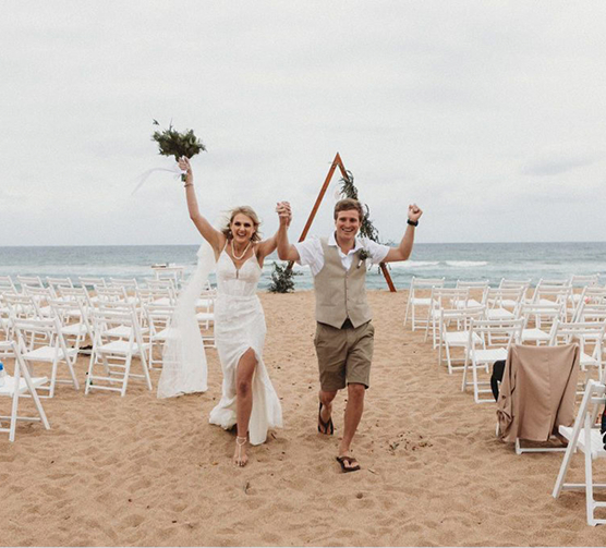 White chairs and wedding arch setup on beach